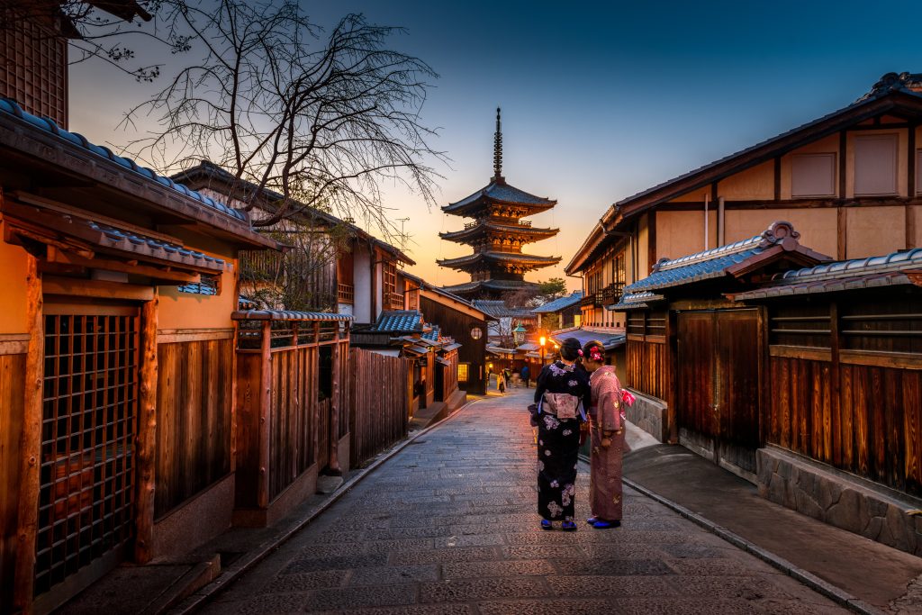 two girls in kimono in the streets of Japan heading to temple
