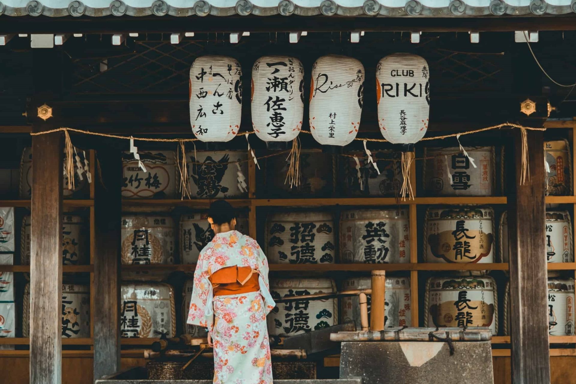 girl in kimono in front of barrels