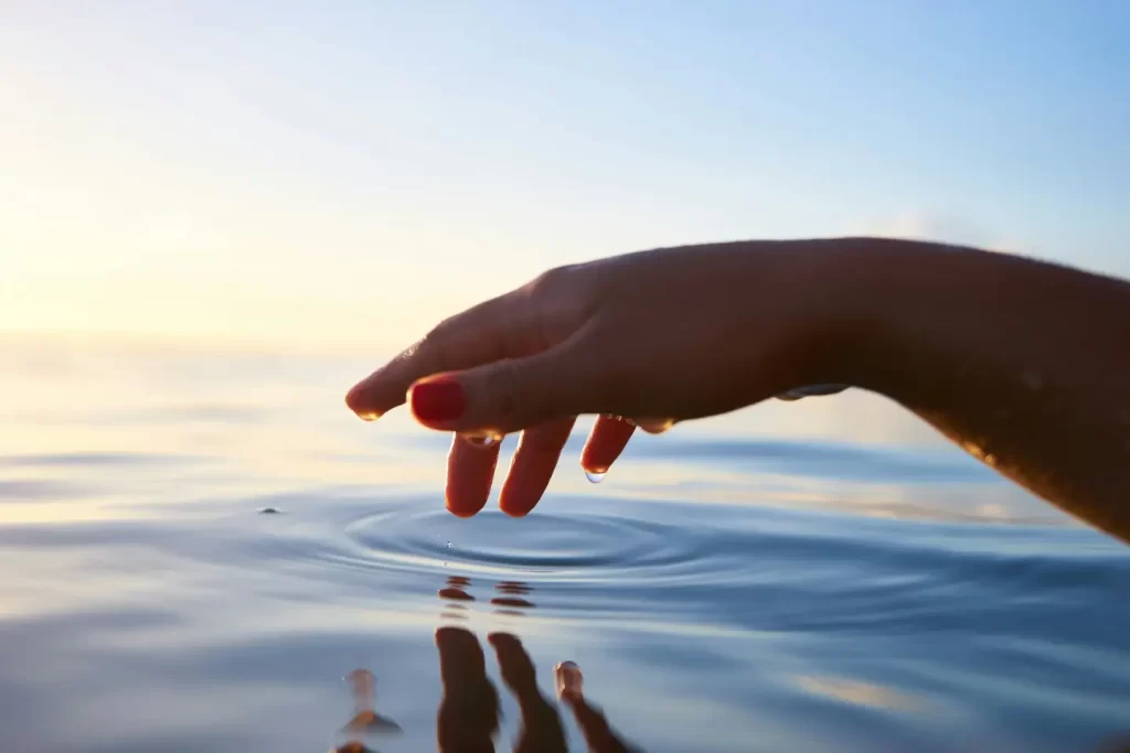person-about-to-touch-the-calm-water